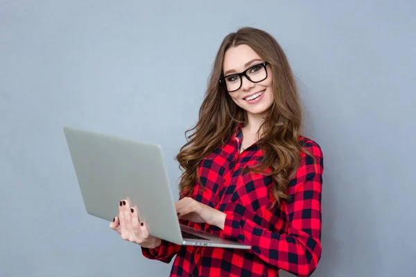 Happy young woman holding laptop