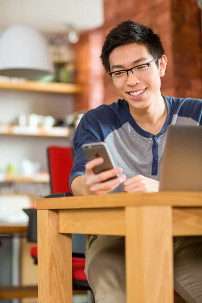 Happy smiling asian student using laptop and cellphone