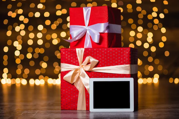 Gift boxes and tablet computer standing on the floor