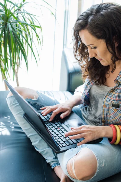 Young lady working on laptop device in room