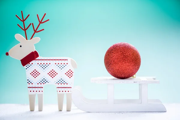 Reindeer and snow sled with christmas ball