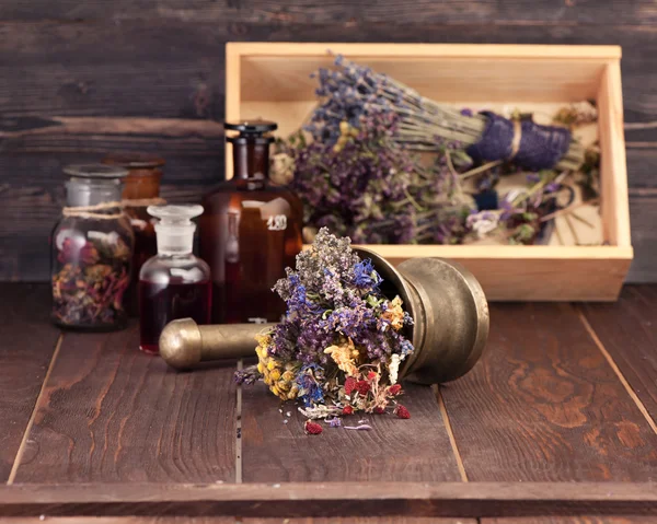Medicinal herbs mortar and bottles tincture in a wooden box. Herbal medicine concept