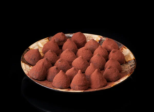 Chocolate candy truffles on a black background
