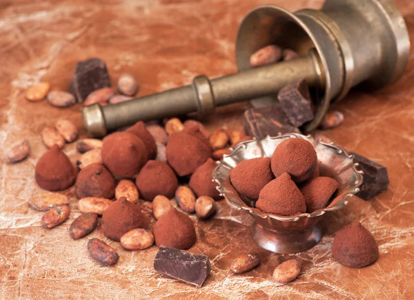 Chocolate truffles, chocolate and cacao beans on a marble backgroun