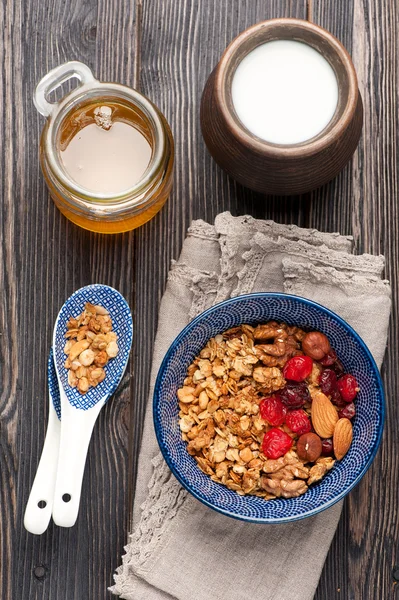 Healthy breakfast.  Oats, granola muesli, nuts, honey, dried berries and milk. Top view.