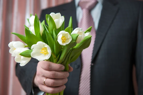 Man - businessman in a suit gives a bouquet of flowers