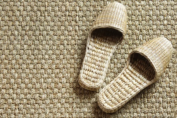 Sea-grass spa slippers on woven carpet