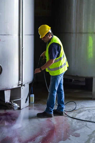 Worker in hard hat pressure washing