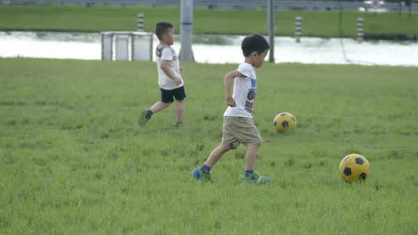 Boys kicking football on the sports field