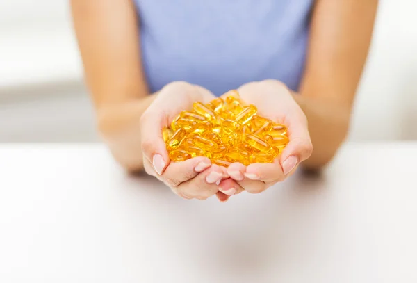 Close up of woman hands holding pills or capsules