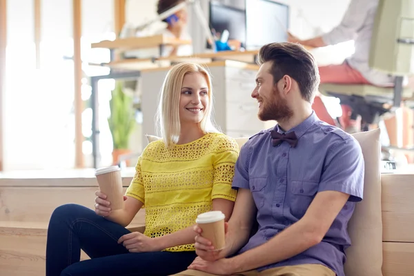 Happy man and woman drinking coffee in office