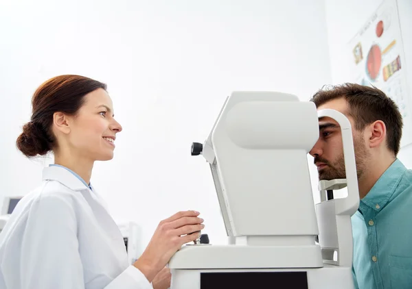 Optician with tonometer and patient at eye clinic