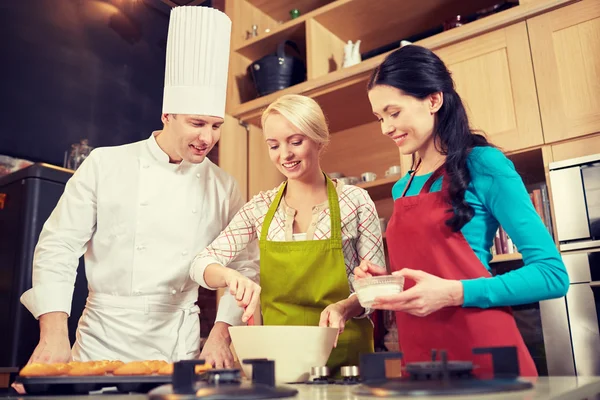 Happy women and chef cook baking in kitchen