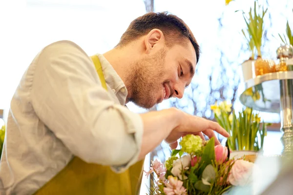 Smiling florist man making bunch at flower shop