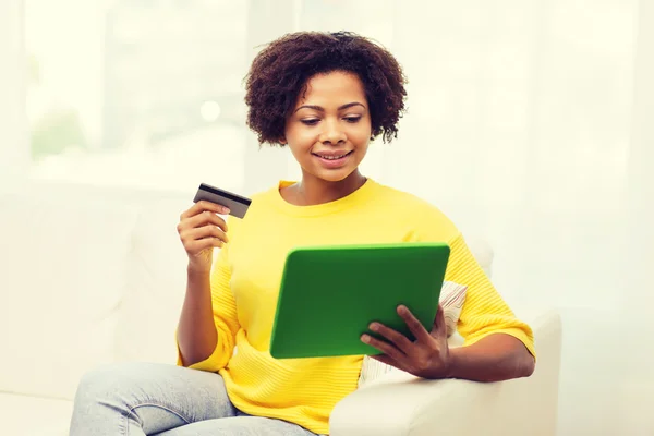 Happy african woman with tablet pc and credit card