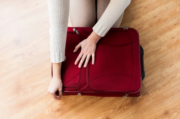 Close up of woman packing travel bag for vacation