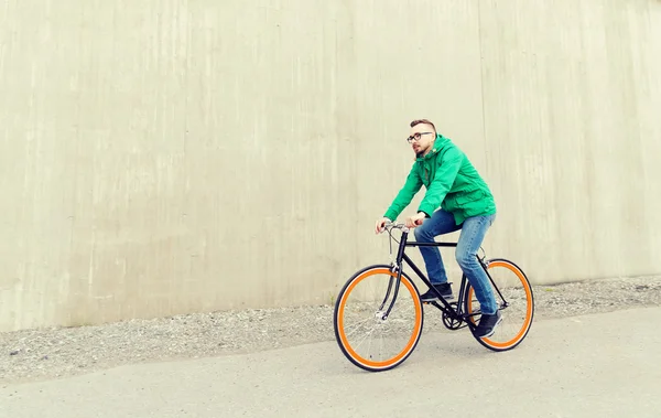 Happy young hipster man riding fixed gear bike