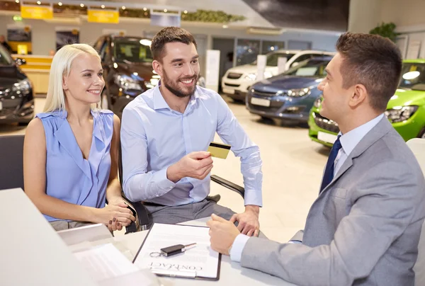 Happy couple with car dealer