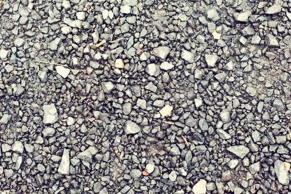 Close up of gray macadam stones on ground