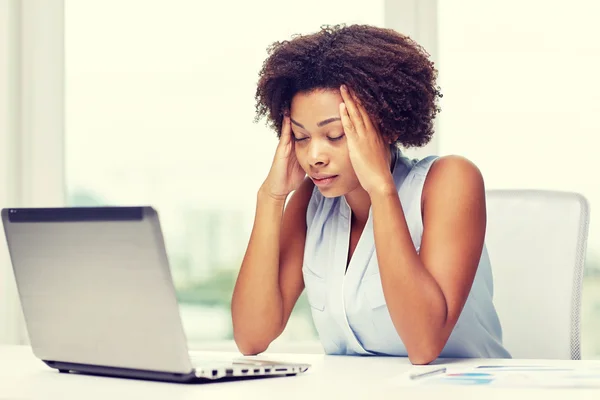 African woman with laptop at office