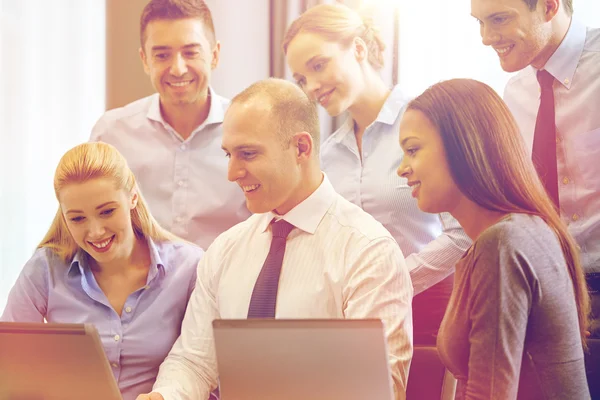 Smiling business people with laptop computer