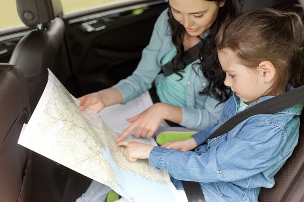Happy family with travel map driving in car