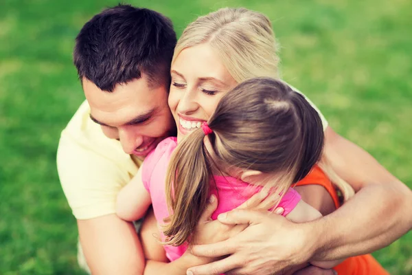 Happy family hugging outdoors