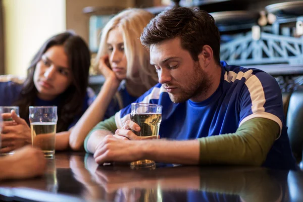 Football fans or friends with beer at sport bar
