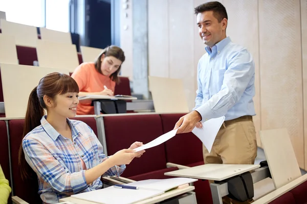 Teacher giving tests to students at lecture