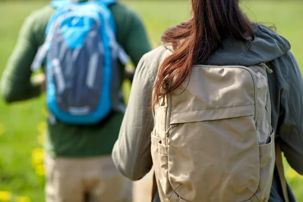 Close up of couple with backpacks hiking outdoors
