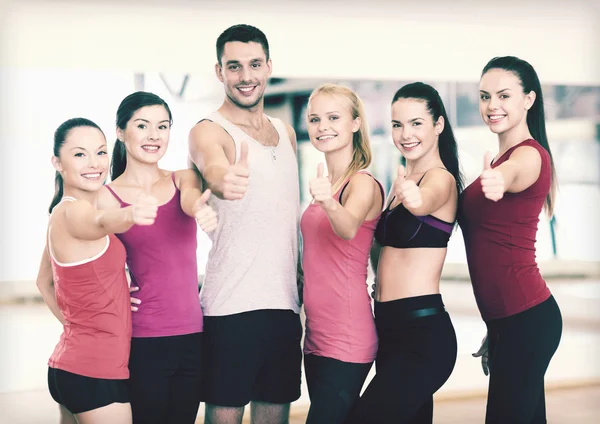 Group of people in the gym showing thumbs up