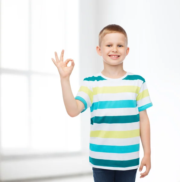 Little boy in casual clothes making ok gesture