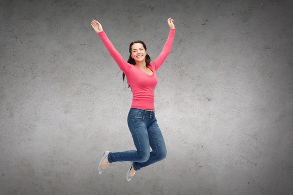 Smiling young woman jumping in air