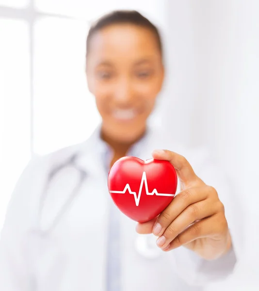 Female doctor holding red heart with ecg line