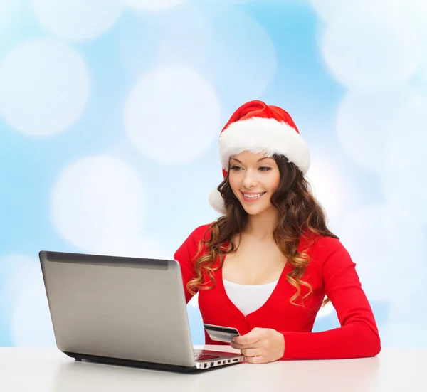 Smiling woman with credit card and laptop