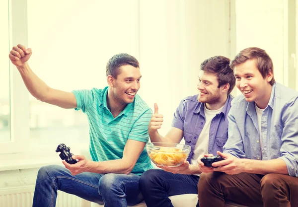 Smiling friends playing video games at home