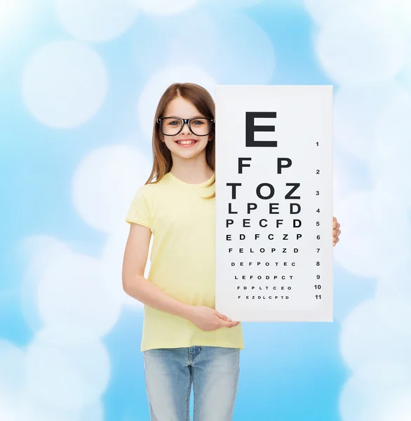 Little girl in eyeglasses with eye checking chart