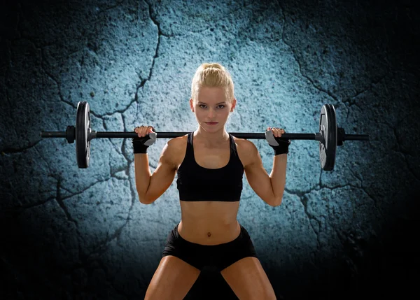 Sporty woman exercising with barbell