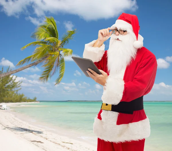 Man in costume of santa claus with tablet pc