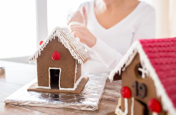 Close up of woman making gingerbread houses