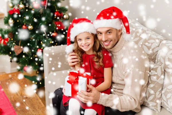 Smiling father and daughter holding gift box