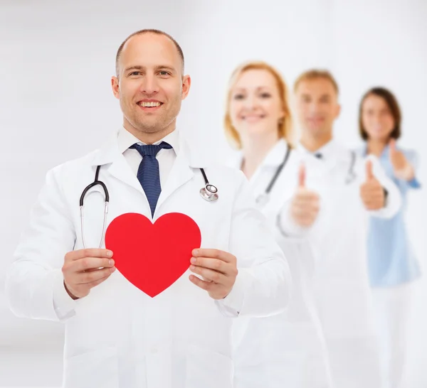 Smiling male doctor with red heart and stethoscope