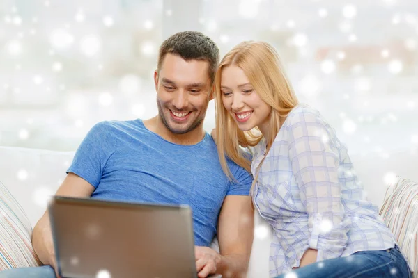 Smiling happy couple with laptop at home