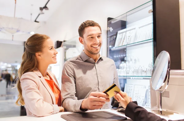 Happy couple choosing engagement ring in mall