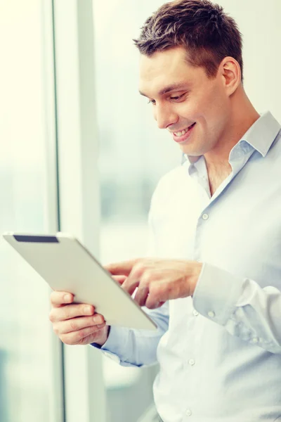 Smiling businessman with tablet pc in office