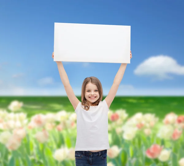 Smiling little girl holding blank white board