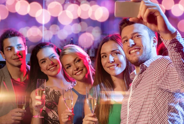 Friends with glasses and smartphone in club
