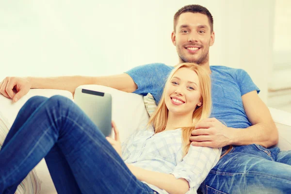 Smiling happy couple with tablet pc at home