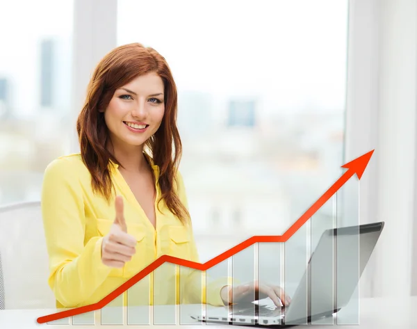 Smiling woman with laptop and growth chart