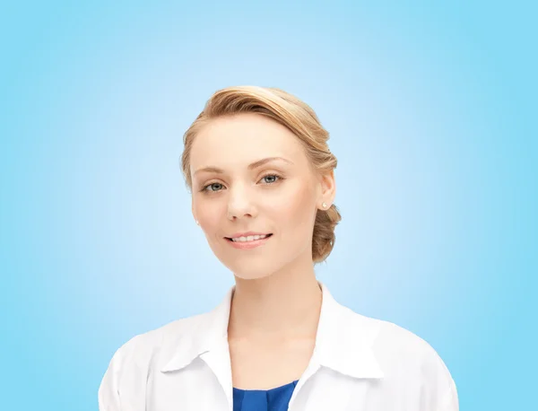 Smiling young female doctor over blue background